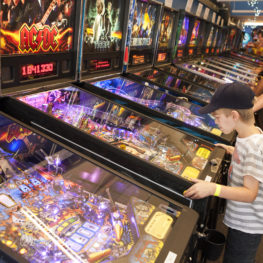Child playing a vintage pinball machine at the Seattle Pinball Museum