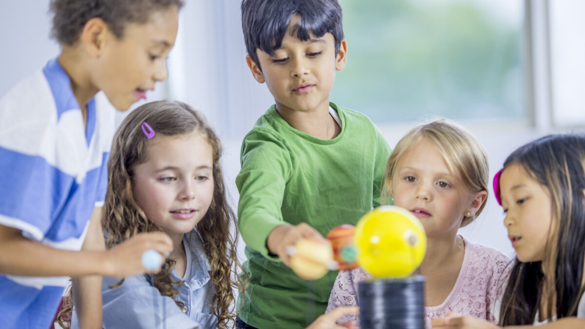 Kids exploring a model solar system during a Seattle-area midwinter break science camp