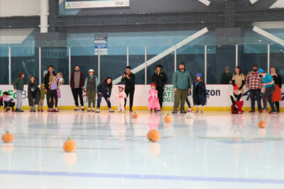 Pumpkin curling at Kraken Community Iceplex, where families enjoy a fun and kid-friendly Halloween activity on the ice.